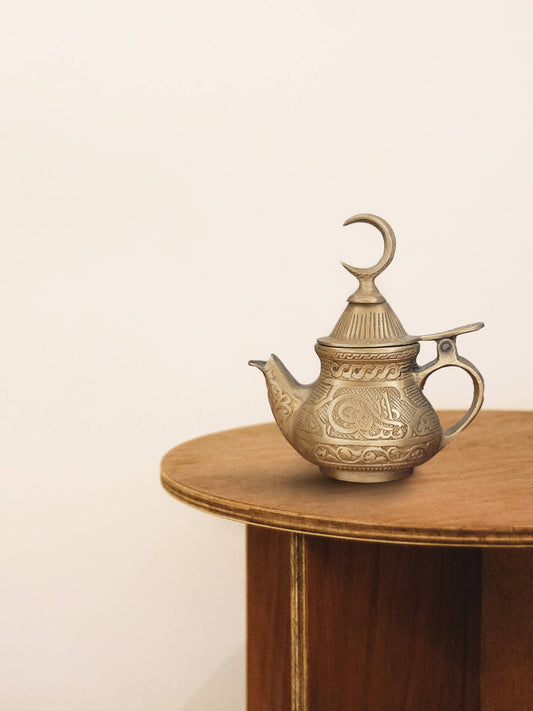 a brass pot kep on the wooden table